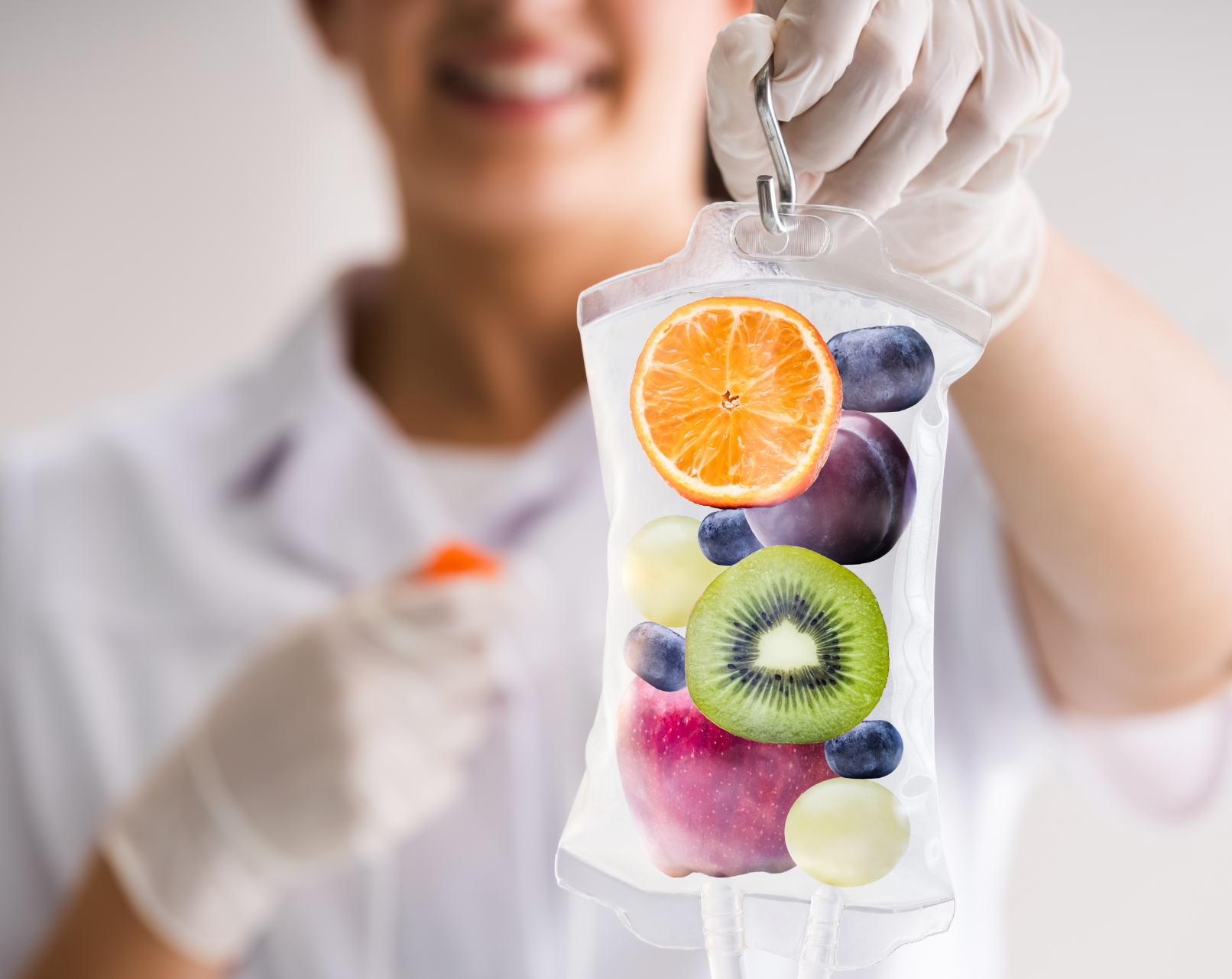 IV Vitamins Nurse Smiling person holding a transparent IV bag filled with fresh fruits—orange, kiwi, grapes, blueberries, and more—symbolizing nutrient-rich wellness. Featured on the Mind Rejuvenation IV Vitamin Therapy page to represent vitality, holistic care, and the power of natural healing.