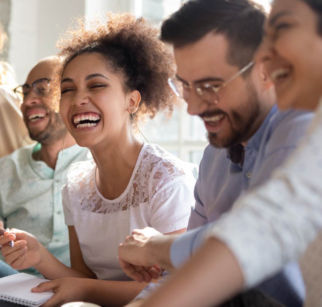 MR People Happy Four people seated together in a sunlit room, smiling and laughing in a moment of connection. Featured on the Mind Rejuvenation Home page to reflect joy, community, and the uplifting power of mental wellness.