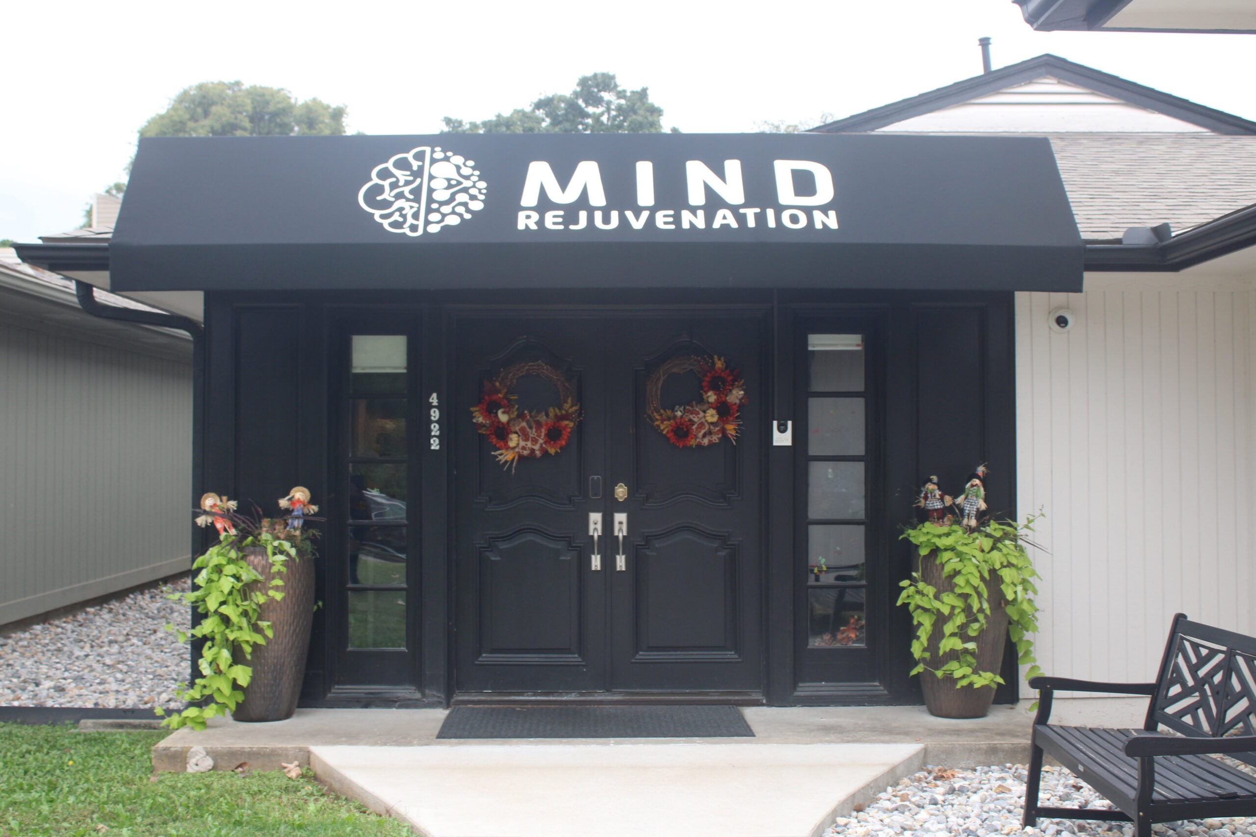 Mind Rejuvenation Entrance Entrance to the Mind Rejuvenation building with black double doors, autumn wreaths, and a bold awning featuring the logo and name. Featured on the About page in the What to Expect section to convey warmth, professionalism, and a welcoming space for mental wellness.
